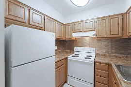 Kitchen with white appliances, wood cabinets and drawers, and a flush mounted ceiling light overhead