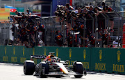 Race winner Max Verstappen passes his team celebrating on the pitwall during the F1 Grand Prix of Azerbaijan at Baku City Circuit on June 12, 2022 in Baku, Azerbaijan.