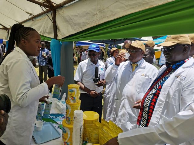 Livestock Principal Secretary Harry Kimtai (centre) samples Brookside Dairy's fortified long life milk at the processor's stand during the University of Eldoret agribusiness trade fair at the weekend.