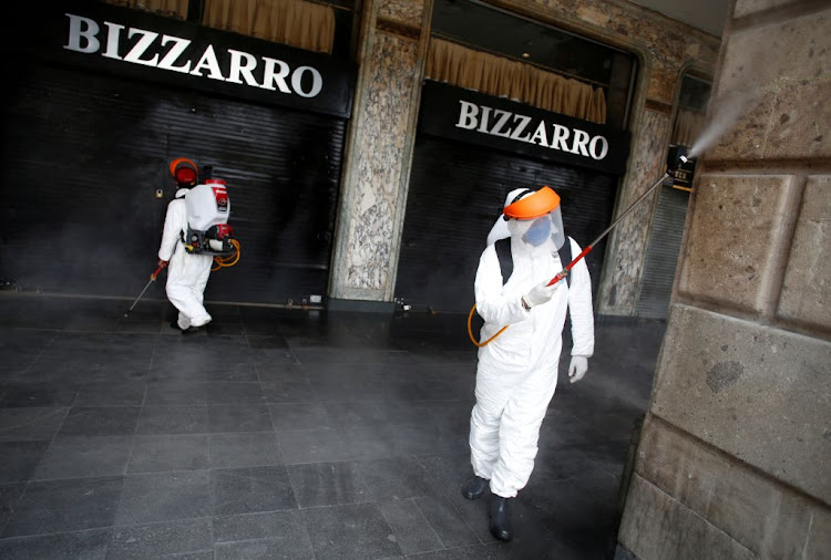 Workers spray disinfectant along the perimeters of Zocalo Square after Mexico entered what the government calls "Phase 3" of the spread of the coronavirus disease, in Mexico City, Mexico, on April 21 2020.