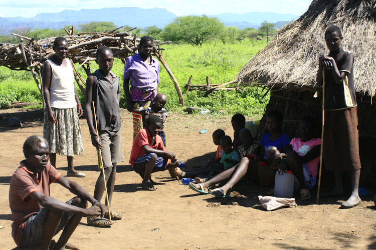 Survivors of banditry attacks crowd outside a grass-thatched hut Ng’aratuko, Baringo North, on May 13