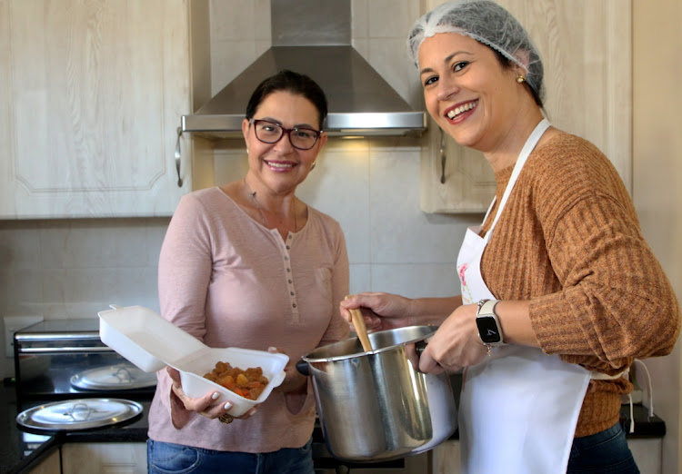 Claudia Skein, left, and Deize Soares cook and distribute food to the less fortunate