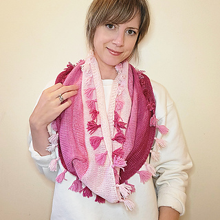 woman wearing knit cowl in shades of pink with tassels