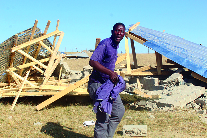 A distraught Siyabulela Mantshongane from Ntabankulu stands next to the rubble of what was once a three-roomed house he had built in March. His house was among 86 structures demolished by Ntabankulu municipal bulldozers on Wednesday.