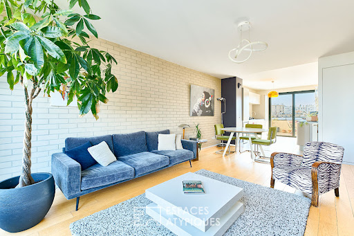 Living room with blue sofa and green plant in this luxury apartment / penthouse for sale in Pantin ($1,436,782 - 133 m²)