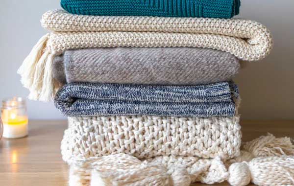 Stack of blankets, one of many cold-weather vacation rental essentials