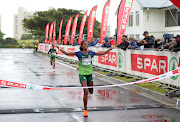 Hiyane Lama of Ethiopia crosses the line to win the Spar Grand Prix Women's 10km race in Green Point, Cape Town ahead of compatriot Selam Gebre (background) on April 23 2023.