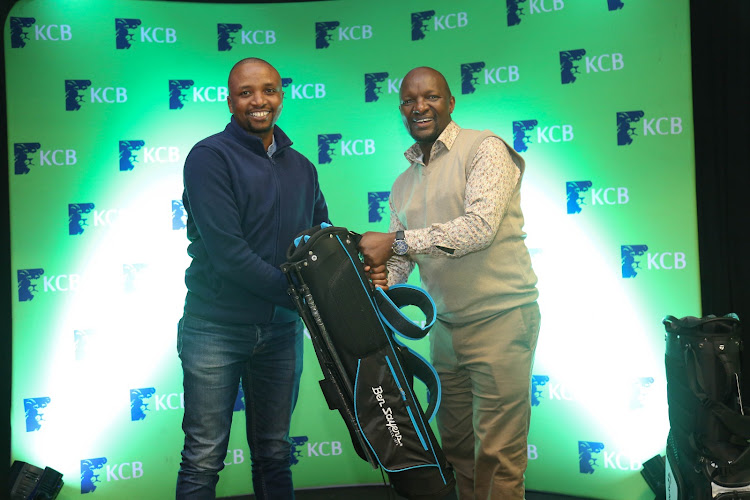 Emmanuel Nyakaberia (L) receives his prize from Simon Mbogo at the Vetlab Golf Club.