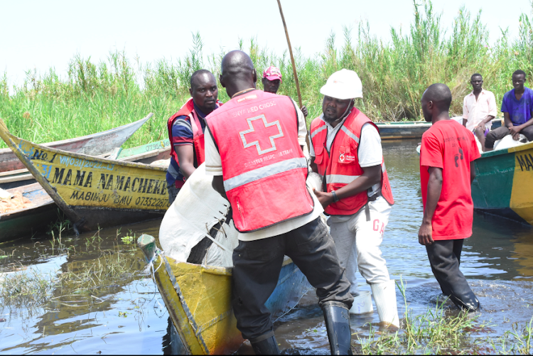 /home/kissfm/Downloads/Kenya Red Cross Volunteers and staff pull a boat load of non-food items at Buluani Village, Busia County after hundreds lost property due to floods on May 15,2023.