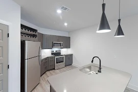 Kitchen featuring island with matte black pendant lighting