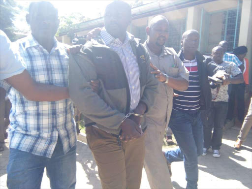 Michael Oyamo (in handcuffs) at the Homa Bay law courts yesterday/ HABIL ONYANGO