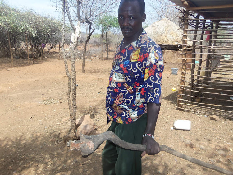 Joseph Kimaru from Mbechot in Baringo holding a sandalwood piece of tree.