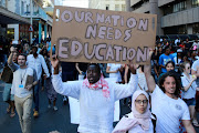 South African students protest outside the parliament precinct before forcing their way through the gates of parliament on October 21, 2015 in Cape Town, South Africa. Protesting students broke through the gates of parliament during protests against a proposed hike in tuition fees this is part of the fees must fall movement.