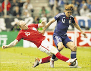 England's Wayne Rooney (L) tackles Japan's Yoshito Okubo during their international friendly soccer match in Graz, May 30, 2010.   REUTERS/Darren Staples   (AUSTRIA - Tags: SPORT SOCCER WORLD CUP)