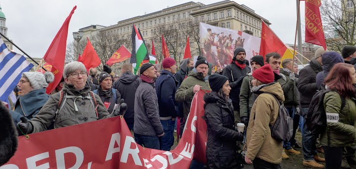 Demonstrantinnen und Demonstranten mit Fahnen und Transparenten.