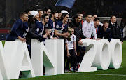 Edinson Cavani of Paris Saint-Germain (PSG) celebrates his trophy for the 200 goals scored for the club with teammattes.