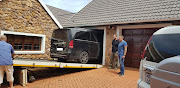 Police and private inspectors remove a black van from the garage of a house in Assagay, west of Durban, on Wednesday. The vehicle is alleged to have been used in the abduction and murder of 20-year-old Siam Lee.