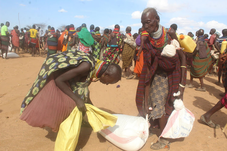 The hunger stricken residents in Kakalel, Lobei/Kotaruk Ward in Loima carrying relief food donation donated by Turkana County Government