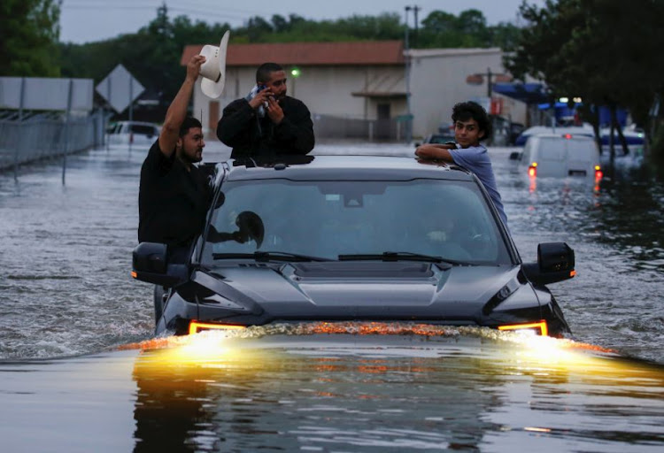 Residents use a truck to navigate through flood waters from Tropical Storm Harvey in Houston, Texas.