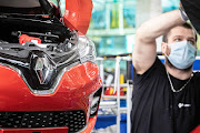 An employee wearing a protective face mask works on the Renault Zoe electric automobile assembly line at the Renault SA factory in Flins, France, on Wednesday, May 6 2020. European car sales were almost wiped out in April after governments around the continent closed auto dealerships and other businesses to slow the spread of the coronavirus.