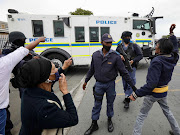 Bishop Lavis residents confronted police outside the suburb's magistrate's court as Zane Kilian was driven away after being charged with the murder of Lt-Col Charl Kinnear.