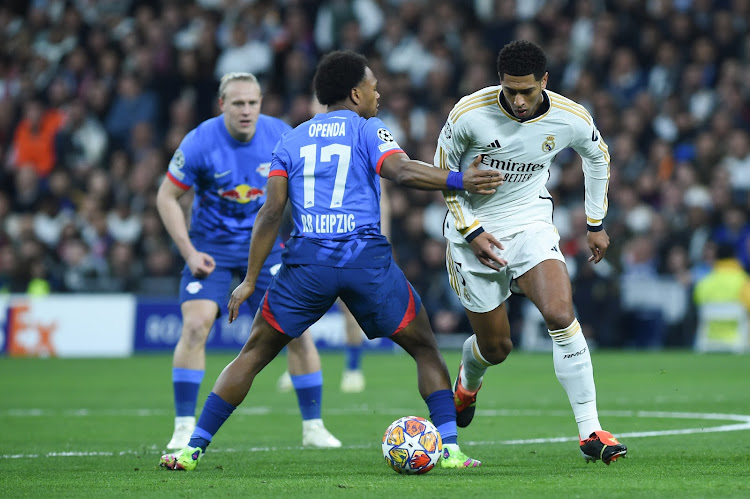 Real Madrid's Jude Bellingham (R) vies for the ball with RB Leipzig's Lois Openda