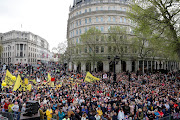 LONDON, ENGLAND - MAY 06: Protesters and well-wishers gather as they wait to watch the procession ahead of the Coronation of King Charles III and Queen Camilla on May 6, 2023 in London, England. The Coronation of Charles III and his wife, Camilla, as King and Queen of the United Kingdom of Great Britain and Northern Ireland, and the other Commonwealth realms takes place at Westminster Abbey today. Charles acceded to the throne on 8 September 2022, upon the death of his mother, Elizabeth II. 