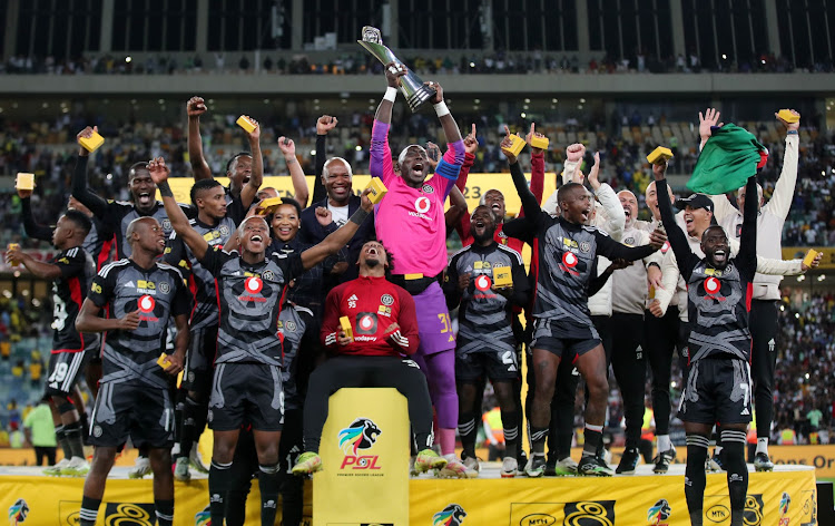 Orlando Pirates players celebrate with MTN8 trophy after they beat Mamelodi Sundowns on penalties at Moses Mabhida Stadium in Durban.