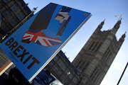 A demonstrator holds a placard during an anti-Brexit protest opposite the Houses of Parliament in London, UK, on December 17 2018. 