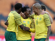 Bafana Bafana star striker Percy Tau (C) celebrates with fellow strikers Dino Ndlovu (R) and Lebo Mothiba (L) after scoring a fourth goal during the 6-0 2019 Africa Cup on Nation romp over Seychelles at FNB Stadium in Soweto, south west of Johannesburg, on October 13,2018.   