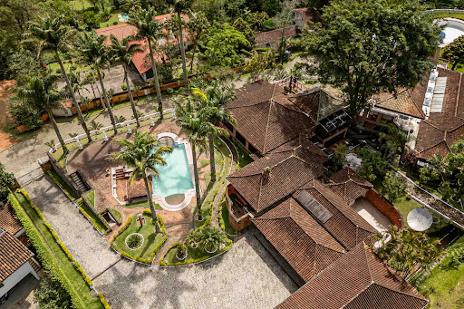 Aerial view house with pool and palm trees in this luxury house for sale in Teresópolis ($4,815,753 - 1,200 m²)