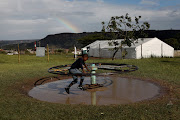 A boy plays outside a temporary shelter for flood victims at KwaNdengezi, west of Durban. The DA says flood victims have received little to no help from the government or the province.