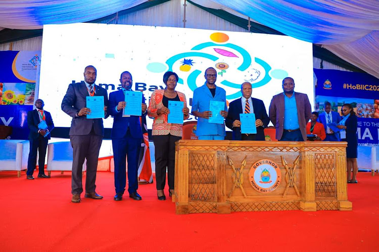 Homa Bay Governor Gladys Wanga and others display MoU documents they signed at the county second edition of international investment conference at Tom Mboya University grounds on February 28,2024