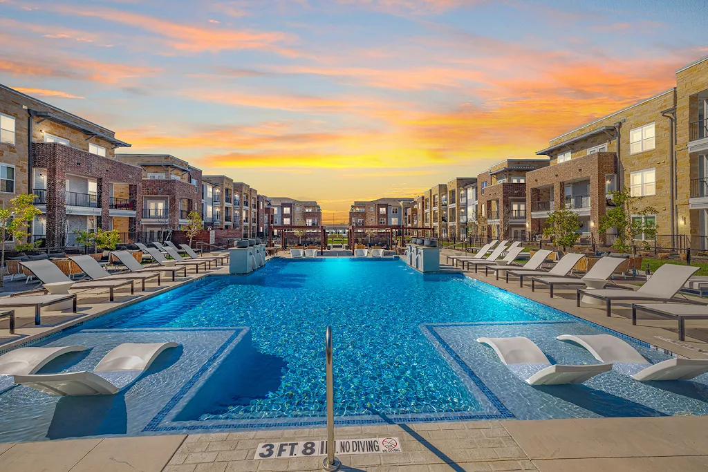 Magnolia Grove's resort-style swimming pool at dusk with lounge chairs surrounding