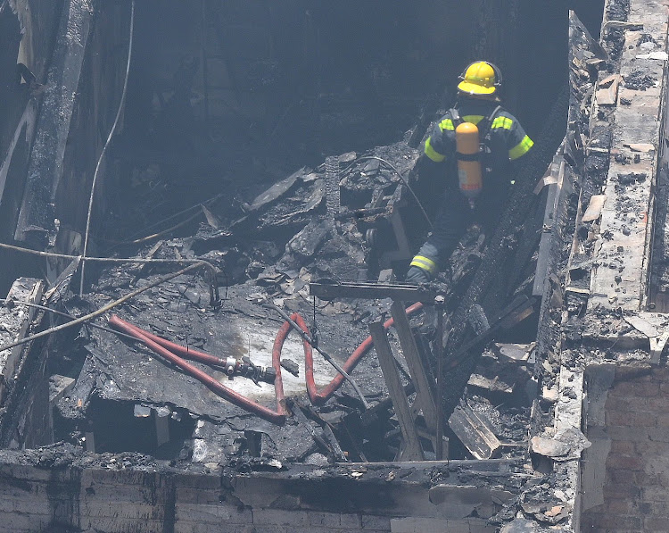 A firefighter in a section of parliament gutted by flames. There was substantial damage to both the New and Old Assembly.