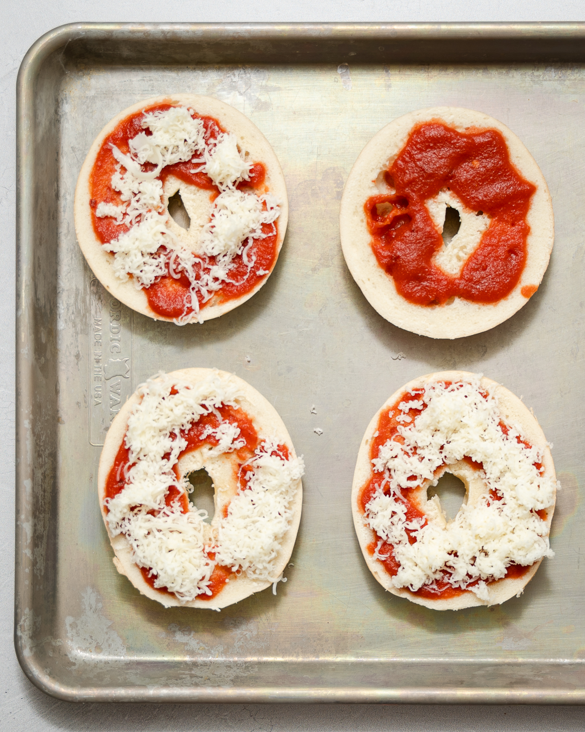 bagels topped with tomato sauce and mozzarella