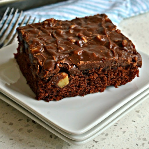 An easy family friendly decadent rich moist chocolate cake that is baked in a jelly roll pan and topped with a simple five ingredient luscious chocolate walnut fudge frosting.