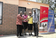 IT'S YOURS: Gauteng MEC for local government and housing, Humphrey Mmemezi, left, congratulates Frans Mulaudzi   and his sisters on their new house in Hammanskraal. The department was marking the start of  its 16 Days Against Women and Children Abuse campaign yesterday. PHOTO SIBUSISO  MSIBI