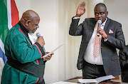 Deputy minister of home affairs Njabulo Nzuza being sworn in by deputy chief justice Raymond Zondo.