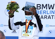 Ethiopia's Guye Adola celebrates on the podium after winning the elite men's race.