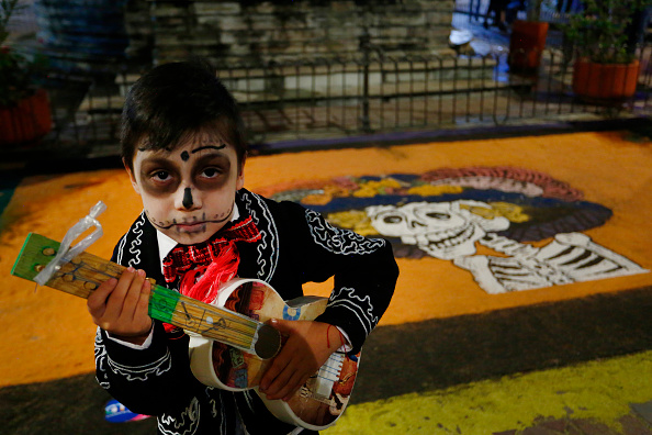 A child poses for a photo in the Plaza del Baratillo in Guanajuato city, Mexico, ahead of the parade of the day of the dead festival.