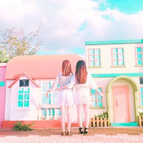 Two friends standing in front of an adorable, Candyland-esque building at the Bicycle Park in Jeungpyeong. / Dispatch