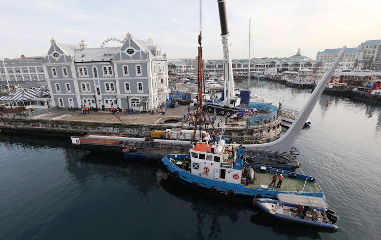 A crane lifts the V&A Waterfront's new swing bridge off a barge on May 25 2019.