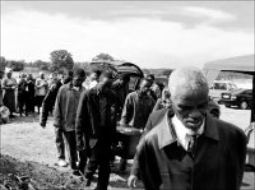 LOVING HANDS: Community leader Luyiso Xulu leads pallbearers at the funeral of destitute Mozambican Victoria Hauti yesterday. Pic. Dan Fuphe. 15/05/08. © Sowetan.