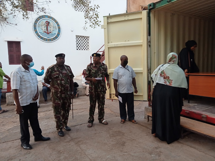 Lamu county commissioner Irungu Macharia and his deputy Charles Kitheka and other officials during the opening of the KCPE exam container in Lamu island.