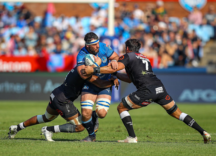 Bulls loose forward Marcell Coetzee is tackled by Sharks No 8 Phepsi Buthelezi and flank Henco Venter during their United Rugby Championship clash at Loftus Versfeld in Pretoria in June 2022.