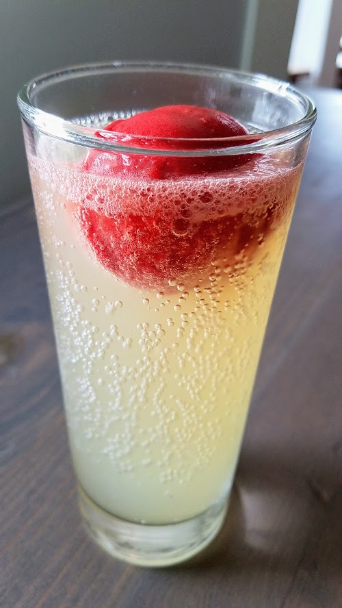 My first look at Outer Darkness Donuts, which on offer here only on Sundays are dark roast drip coffees, fun mimosas, loose leaf tea, and only one food dish you can order: a flight of mini-donuts. Here's one of the mimosas, the Strawberry Sorbet Float mimosa with elderflower and yuzu