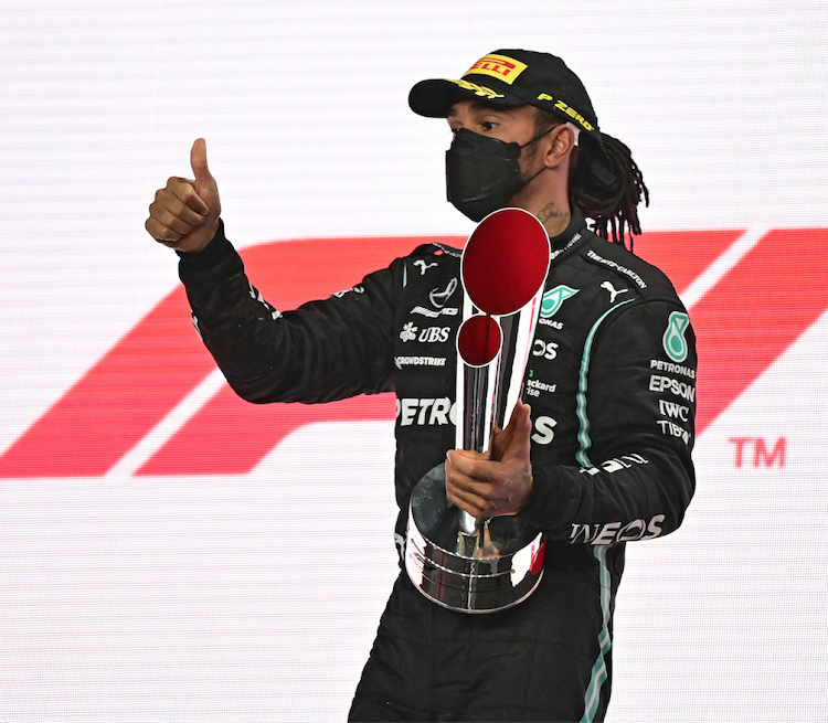 Mercedes driver Lewis Hamilton celebrates with the trophy after winning the Qatari Formula One Grand Prix at the Losail International Circuit on November 21