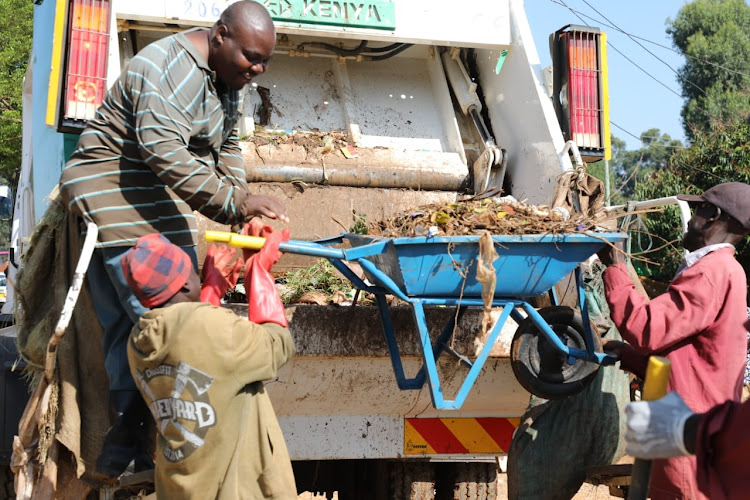 Cleaners load garbage onto a compactor before it is transported to the dumpsite in Esibuye, Emuhaya subcounty, Vihiga county.