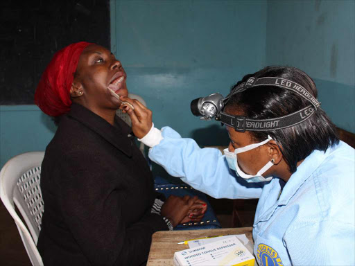 A dental surgeon examines a patient. /FILE